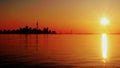 Silhouette of TorontoÃ¢â¬â¢s skyline juxtaposed to the rising sun over Lake Ontario. Royalty Free Stock Photo